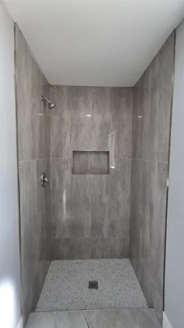 an empty room with wooden floor chandelier fan and windows