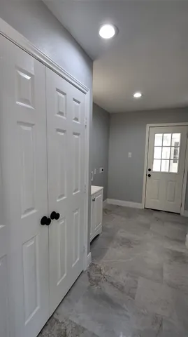 a view of hallway with a mirror and wooden floor