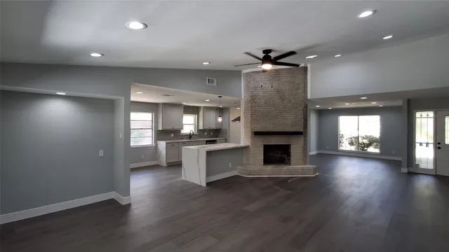 an open kitchen view with fireplace and wooden floor