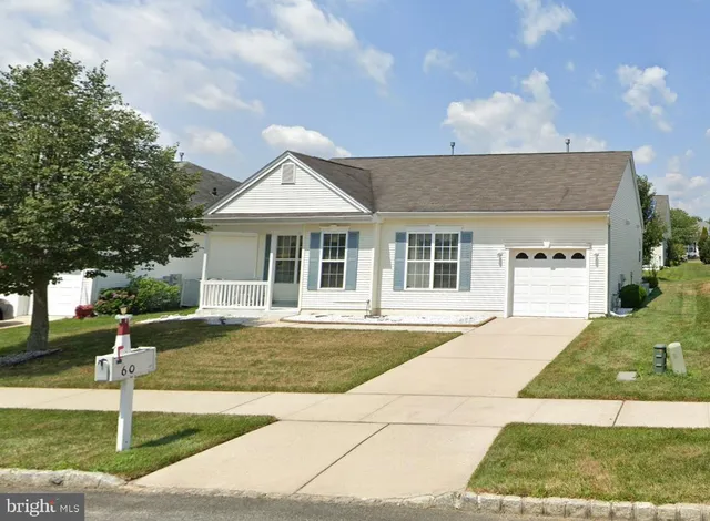 a front view of a house with a yard and potted plants