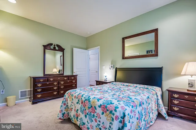 a bedroom with a bed and dresser with mirror