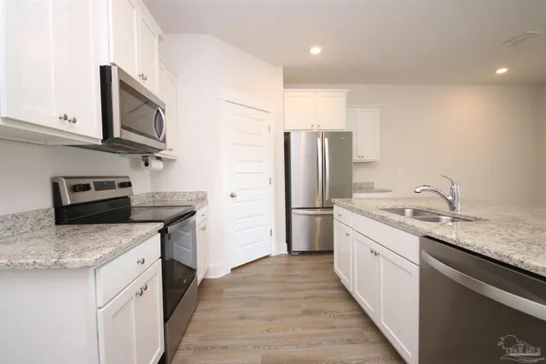 a kitchen with stainless steel appliances granite countertop a sink stove and refrigerator