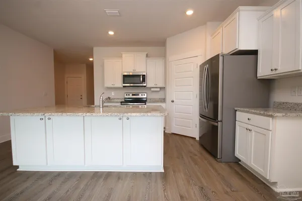 a kitchen with stainless steel appliances a refrigerator sink and microwave