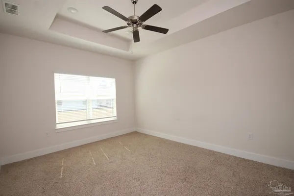 an empty room with a window and a fan