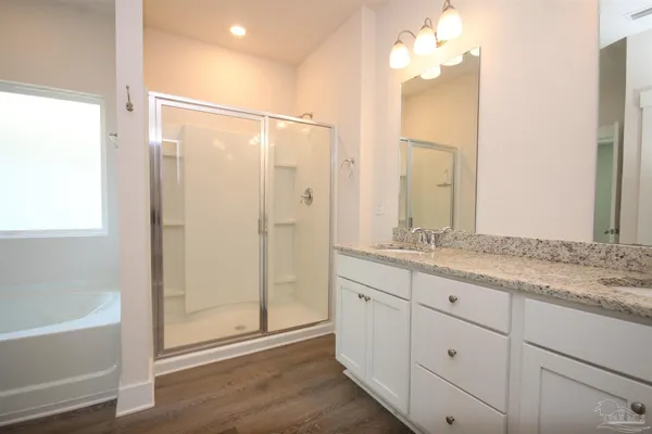 a bathroom with a granite countertop sink a mirror and a bathtub