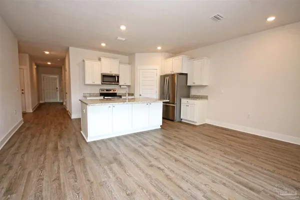 a kitchen with stainless steel appliances granite countertop a stove and a refrigerator