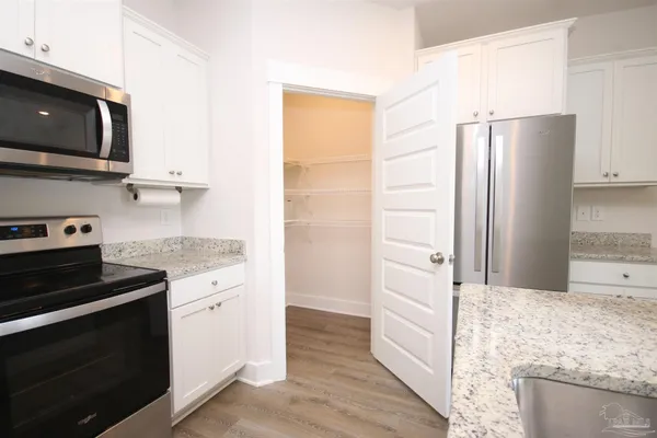 a kitchen with stainless steel appliances granite countertop a refrigerator stove and sink