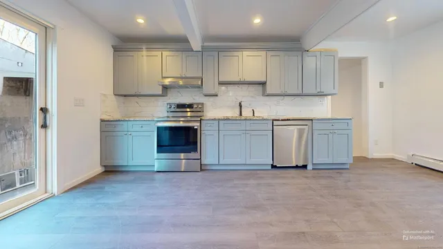 a kitchen with stainless steel appliances granite countertop a stove sink and cabinets