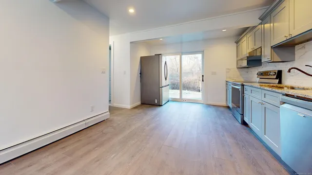 a kitchen with stainless steel appliances a refrigerator and wooden floor