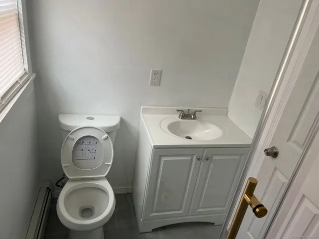 a bathroom with a toilet a sink and a mirror