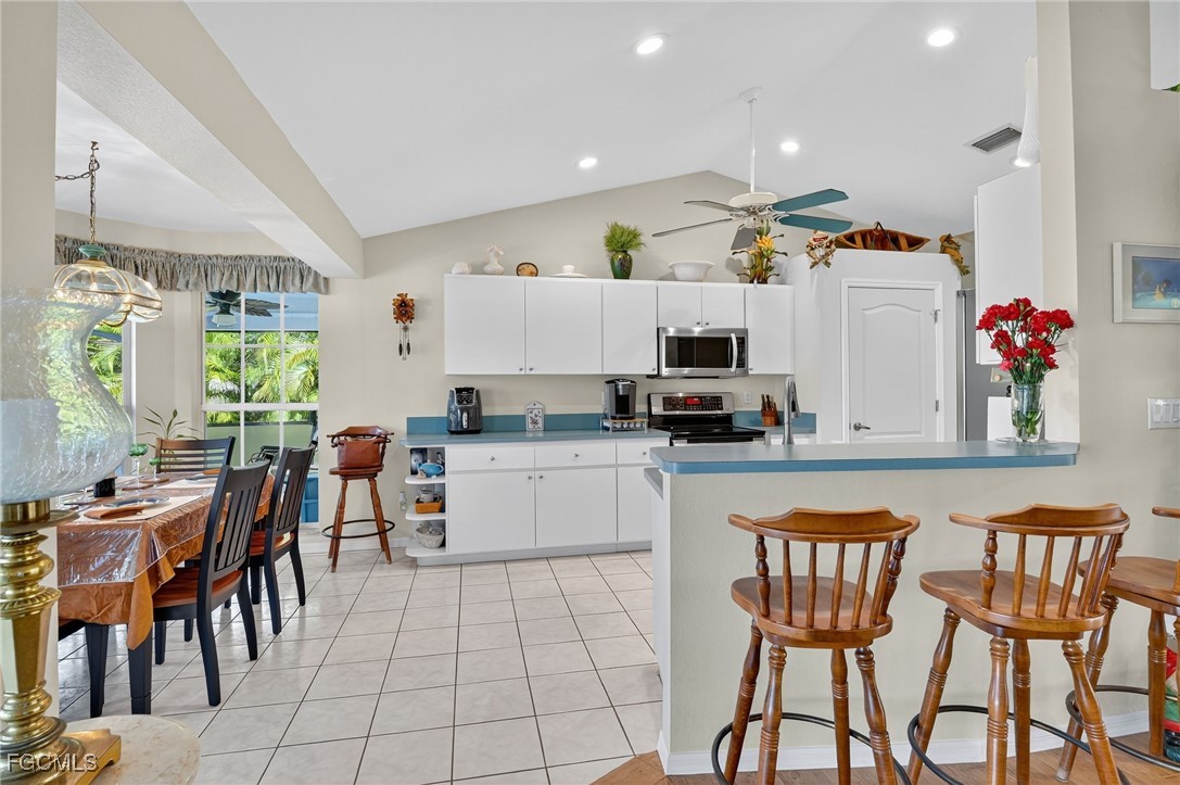 4306 Southwest 3rd Avenue Cape Coral, FL 33914 - Photo 11 of 50 a kitchen with a dining table chairs and white appliances