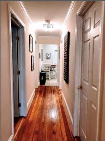 a view of a hallway with wooden floor and staircase