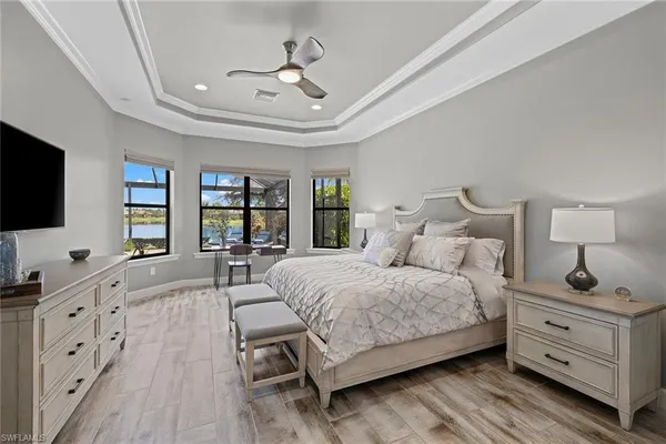 a spacious bedroom with a bed and a flat screen tv