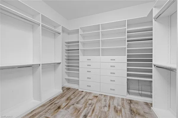 a view of walk in closet with empty racks