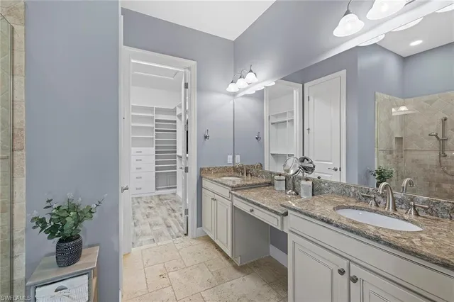 a bathroom with a granite countertop sink a large mirror and a shower