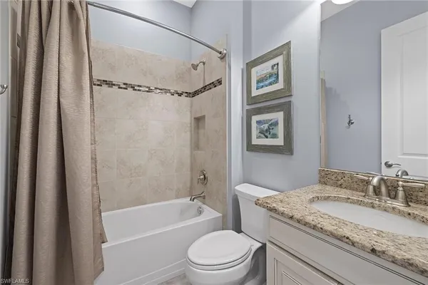 a bathroom with a granite countertop sink toilet tub and shower