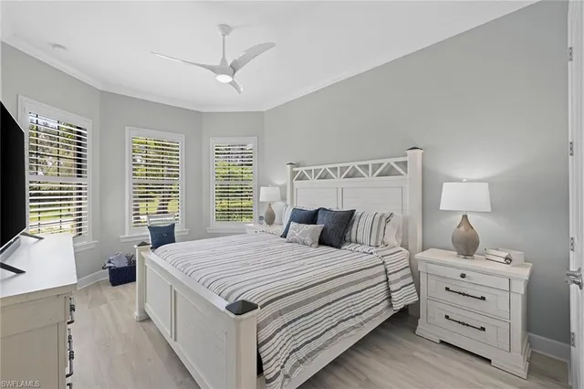 a bedroom with a large bed and a flat tv screen on dresser