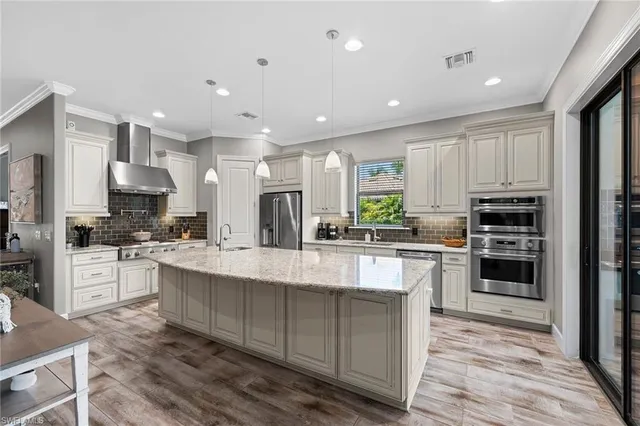 a large kitchen with stainless steel appliances lots of counter space and a refrigerator