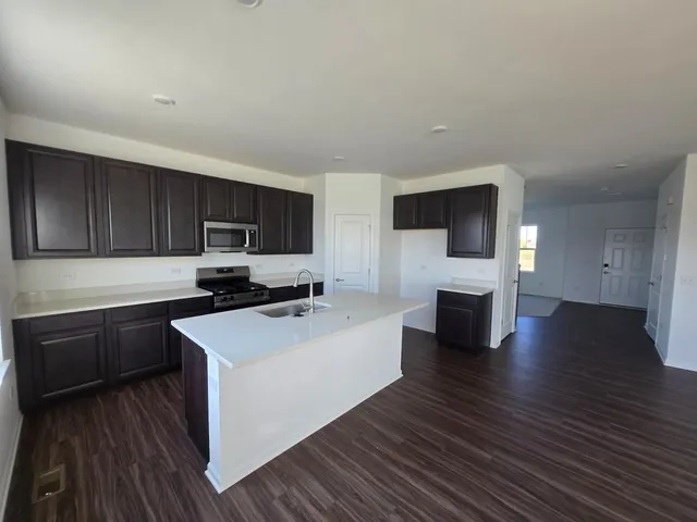a kitchen with sink cabinets and wooden floor