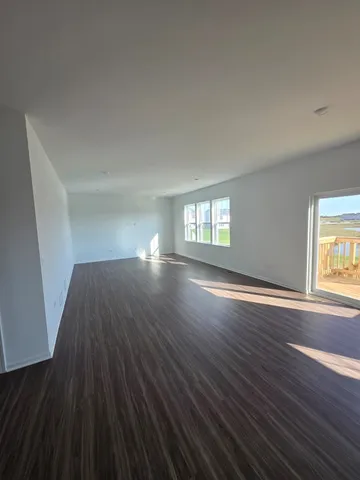 a view of empty room with window and wooden floor