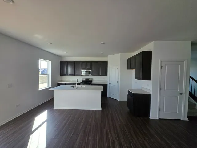 a living room with stainless steel appliances wooden floors and view living room