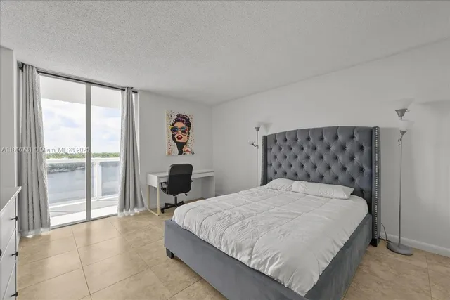 a large bed sitting in a bedroom next to a window