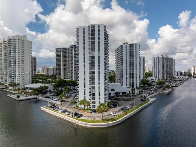 a view of swimming pool of water with lawn chairs and barbeque oven