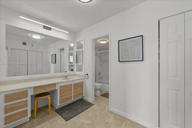 a large white bathroom with a double vanity sink and a mirror