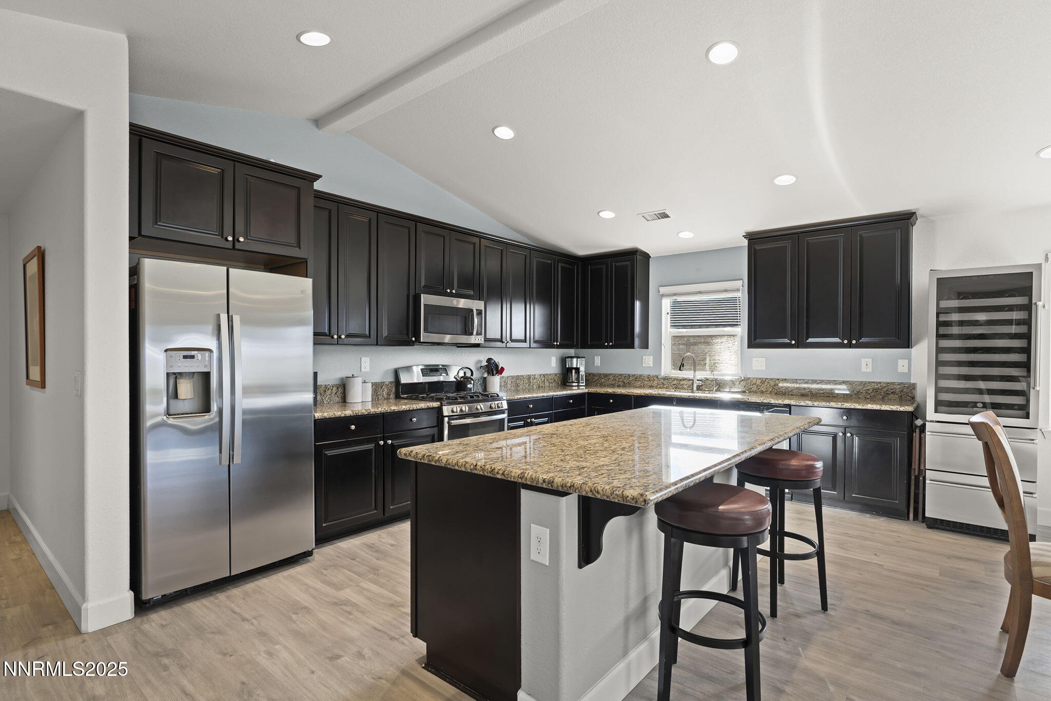 7707 Rhythm Circle Sparks, NV 89436 - Photo 8 of 30 a kitchen with stainless steel appliances granite countertop a stove a sink a microwave a refrigerator and chairs