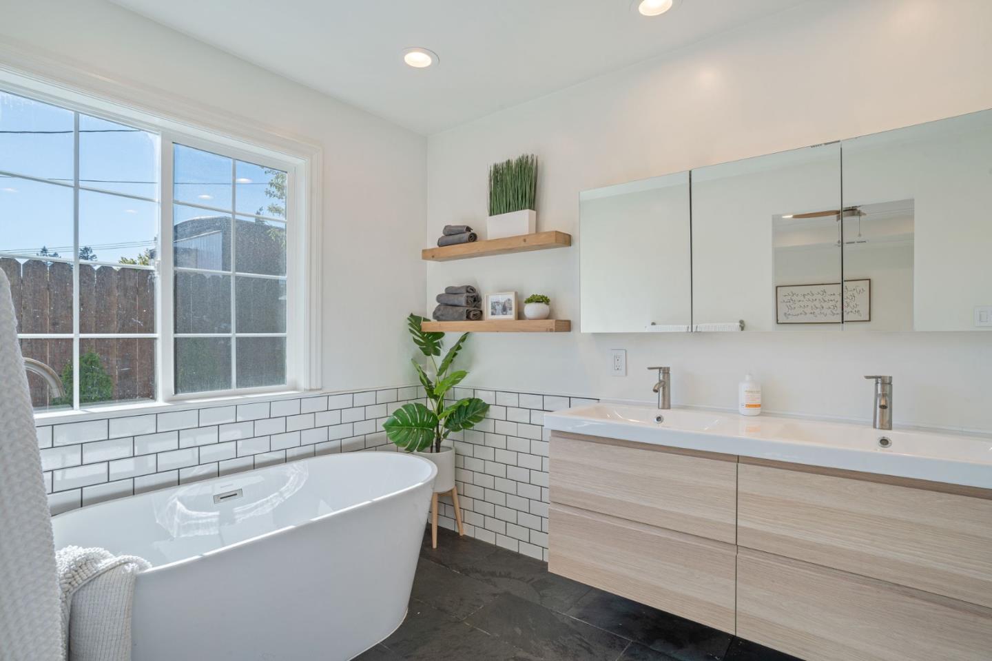 1851 Nash Drive San Mateo, CA 94401 - Photo 17 of 46 a bathroom with a bathtub a sink a window and a mirror