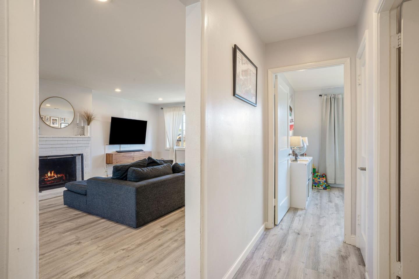 1851 Nash Drive San Mateo, CA 94401 - Photo 24 of 46 a living room with furniture a fireplace and a flat screen tv