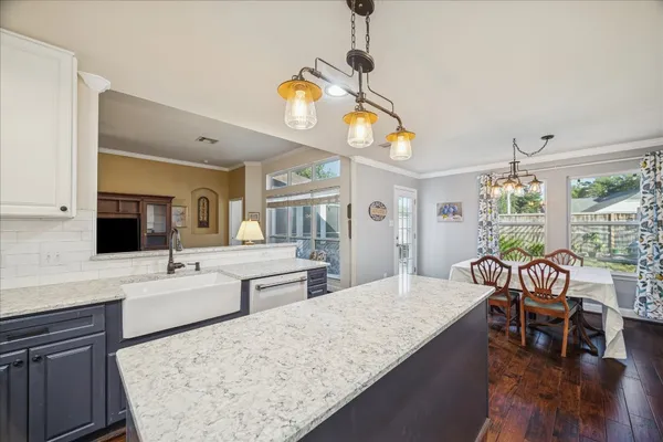 a living room with granite countertop kitchen island furniture and a flat screen tv