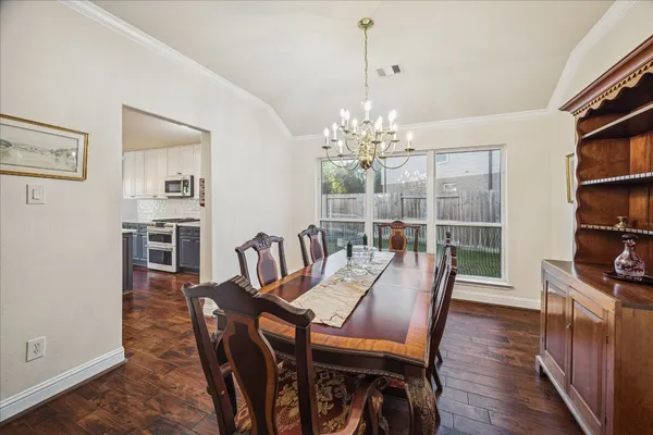 a view of a dining room with furniture wooden floor and a chandelier