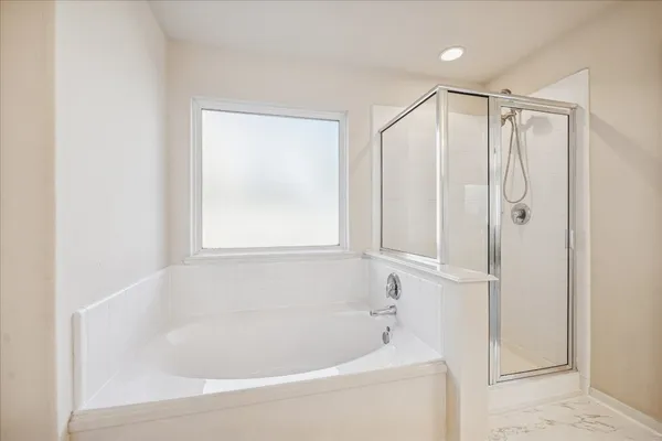 a white bath tub sitting next to a shower
