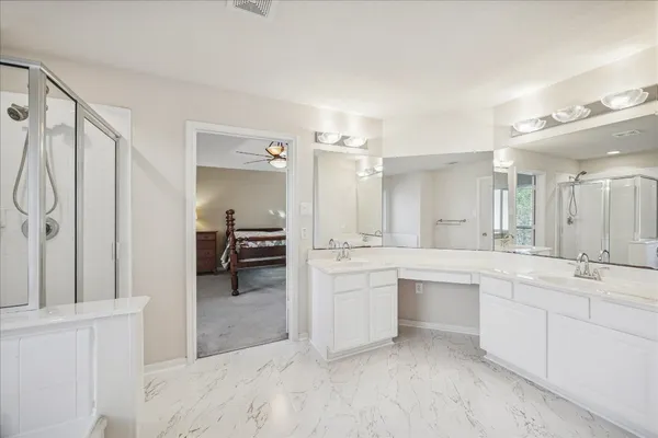 a large white kitchen with a sink and dishwasher a refrigerator with white cabinets