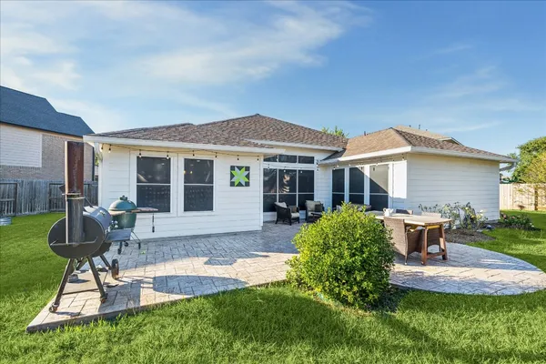 a view of a house with backyard sitting area and garden