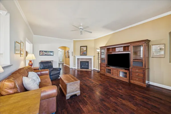 a living room with furniture a flat screen tv a wooden floor and a fireplace