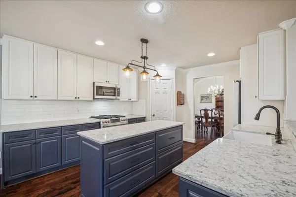 a kitchen with granite countertop a sink stove and cabinets