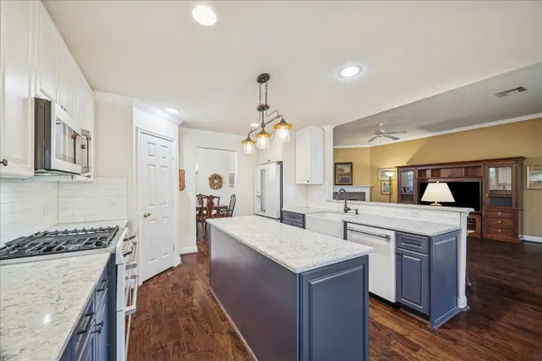 a large kitchen with sink a refrigerator and wooden cabinets