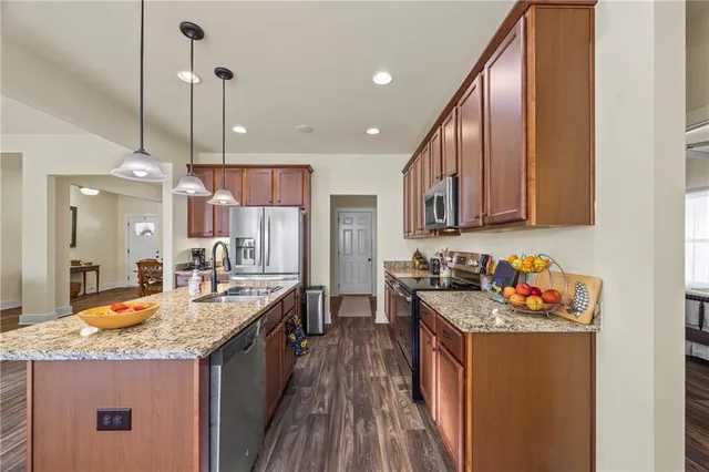 a kitchen with stainless steel appliances granite countertop a stove a sink and a refrigerator
