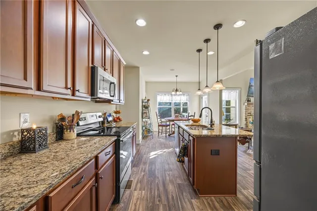 a kitchen with stainless steel appliances granite countertop sink stove top oven and cabinets