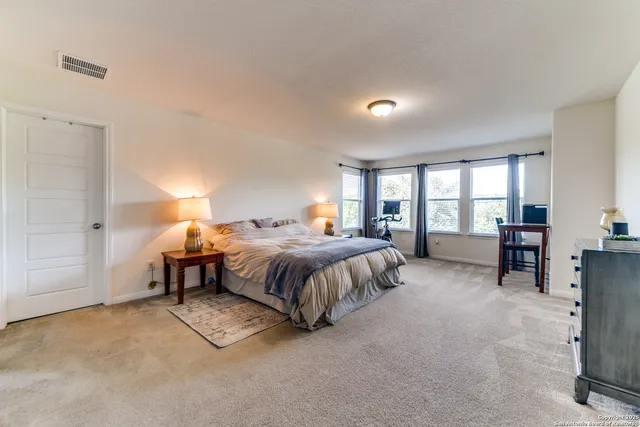 a spacious bedroom with a bed and a cabinets