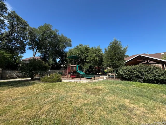 a view of a swimming pool with a bench and trees