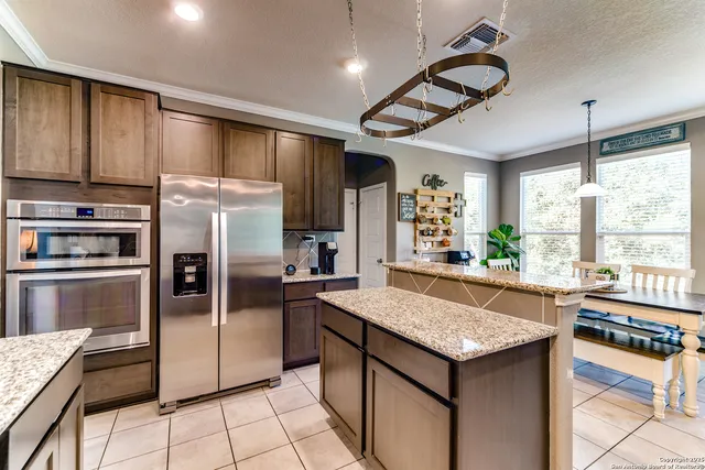 a kitchen with granite countertop stainless steel appliances a counter space and a refrigerator