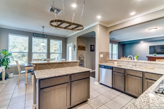 a kitchen with granite countertop a sink and a refrigerator
