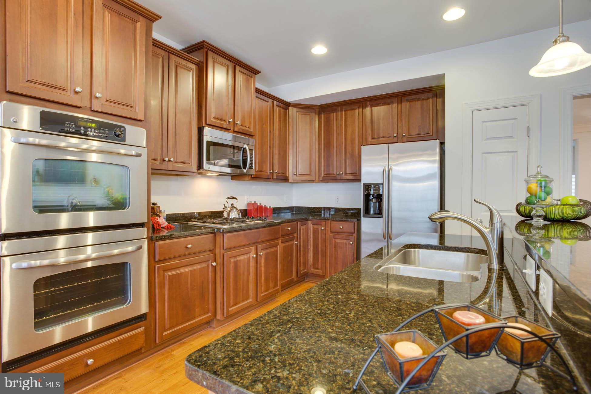 5723 Callcott Way, Unit M Alexandria, VA 22312 - Photo 11 of 28 a kitchen with stainless steel appliances granite countertop a stove a sink and a microwave