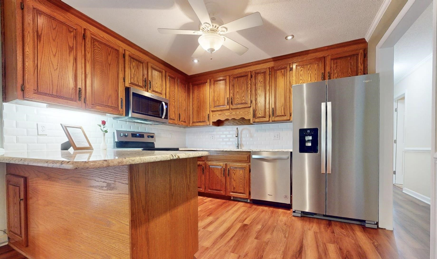 826 Chip Circle Cary, NC 27513 - Photo 12 of 44 a kitchen with stainless steel appliances granite countertop a refrigerator stove top oven a sink and dishwasher with wooden floor