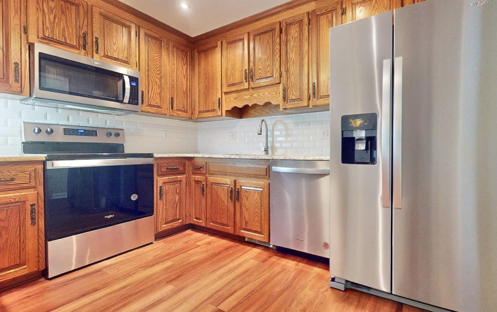 826 Chip Circle Cary, NC 27513 - Photo 13 of 44 a kitchen with stainless steel appliances granite countertop wooden cabinets a sink and a microwave