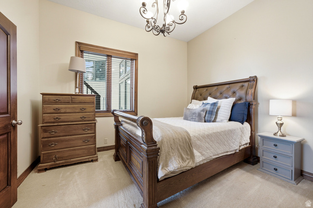 335 Bern Way Midway, UT 84049 - Photo 51 of 88 Bedroom featuring a window with wood blinds, a dark wood door, light beige walls, and neutral carpet flooring
