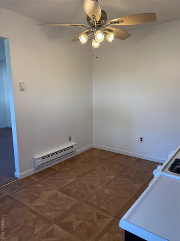 an empty room with a ceiling fan and carpet
